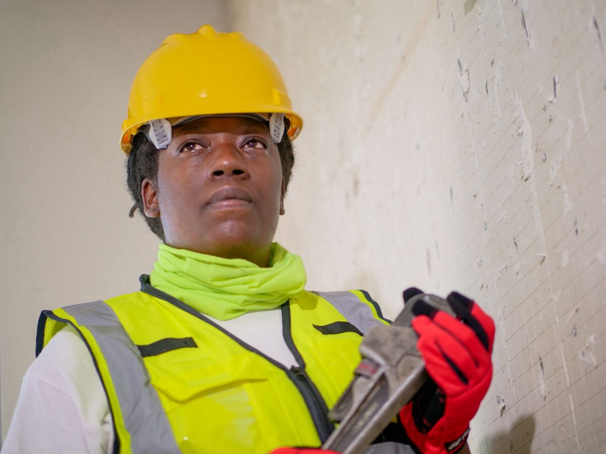 A worker in a hard hat and high visibility vest on a job site.